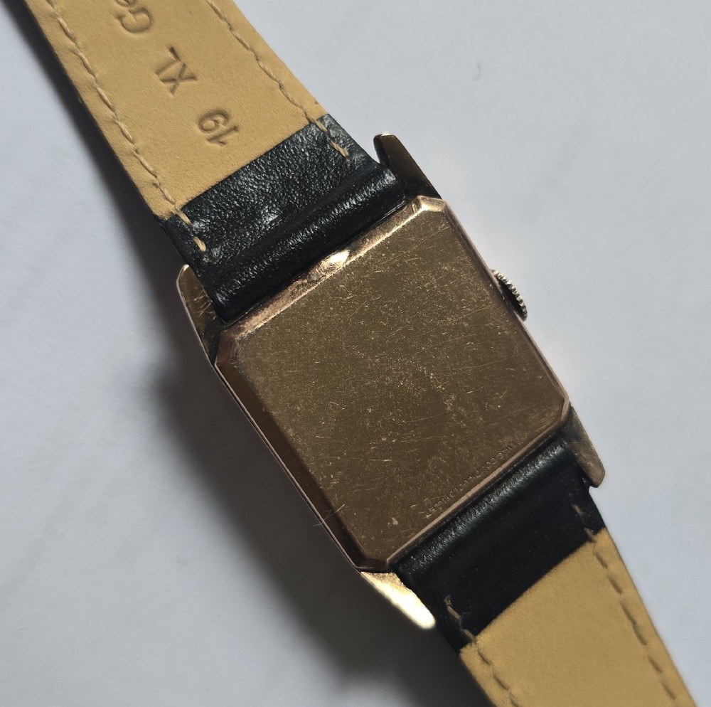 A vintage Longines rectangular wristwatch featuring a rose gold-filled case, patinated dial with Arabic numerals, sub-seconds register, and a black leather strap. View XV