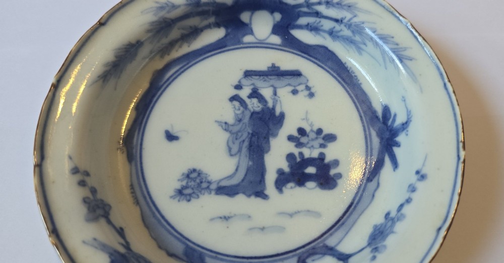 A circular Edo period Japanese Arita porcelain shallow dish featuring hand-painted cobalt blue underglaze figurative and floral decoration on an off-white ceramic body. View III