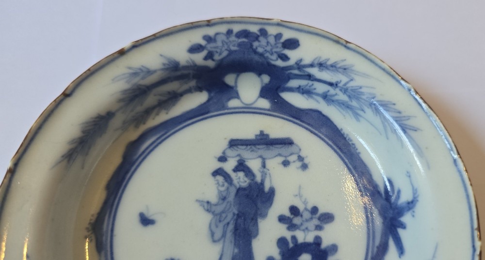 A circular Edo period Japanese Arita porcelain shallow dish featuring hand-painted cobalt blue underglaze figurative and floral decoration on an off-white ceramic body. View IV