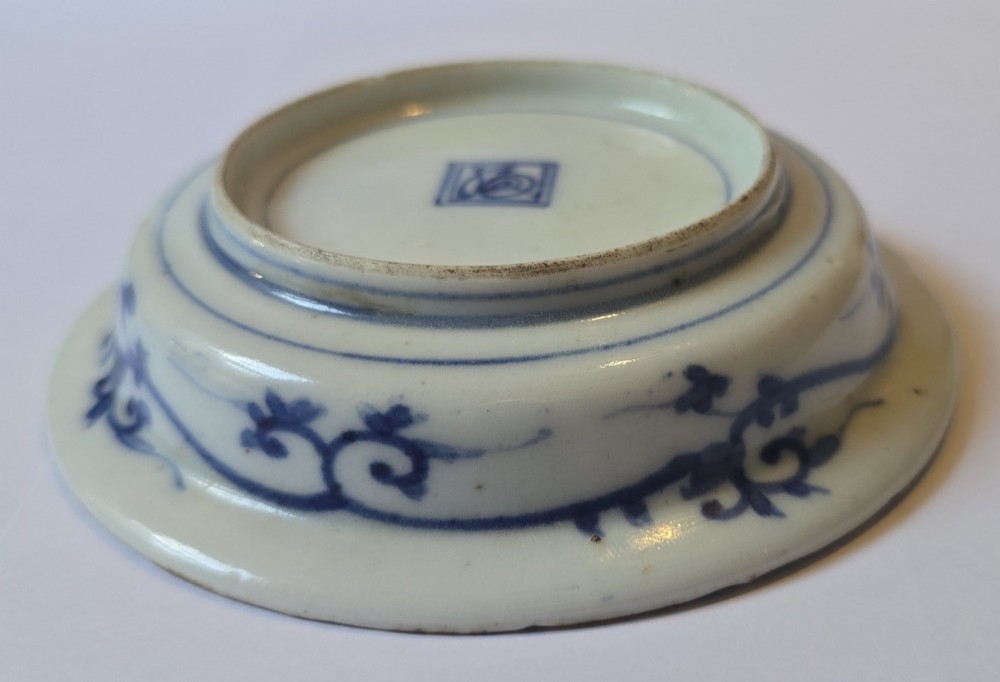 A circular Edo period Japanese Arita porcelain shallow dish featuring hand-painted cobalt blue underglaze figurative and floral decoration on an off-white ceramic body. View VIII