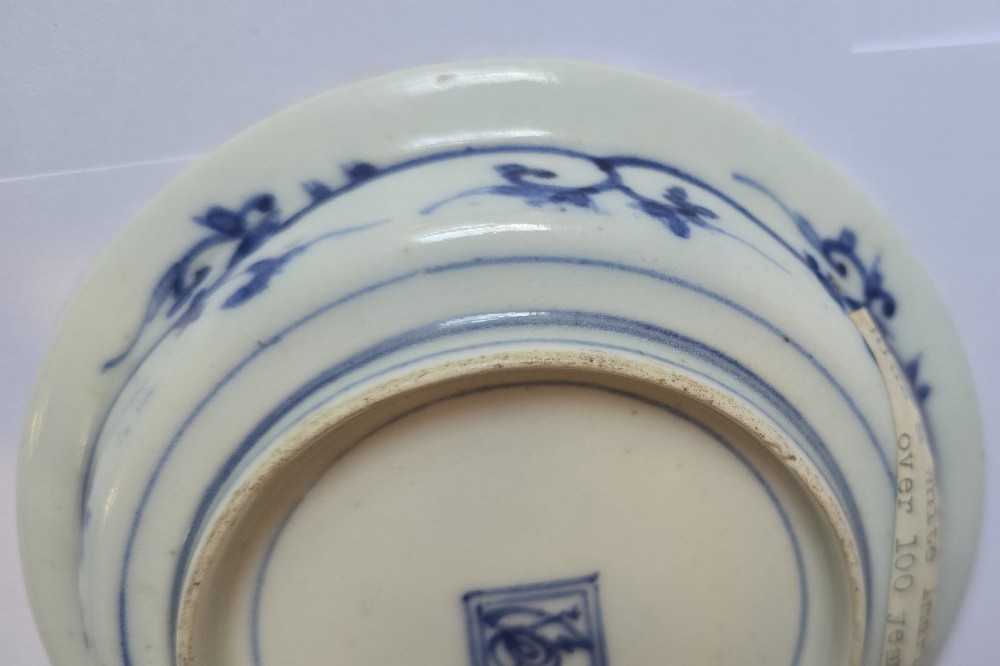 A circular Edo period Japanese Arita porcelain shallow dish featuring hand-painted cobalt blue underglaze figurative and floral decoration on an off-white ceramic body. View IX