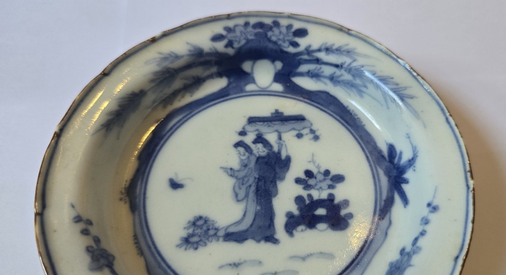 A circular Edo period Japanese Arita porcelain shallow dish featuring hand-painted cobalt blue underglaze figurative and floral decoration on an off-white ceramic body. View XIV