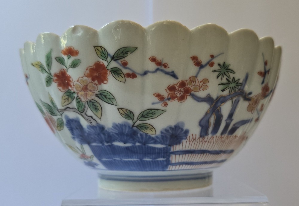 A fluted late 17th-century Japanese porcelain bowl decorated with polychrome floral enamel motifs against an off-white background. View VI