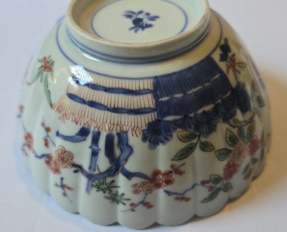 A fluted late 17th-century Japanese porcelain bowl decorated with polychrome floral enamel motifs against an off-white background. View IX