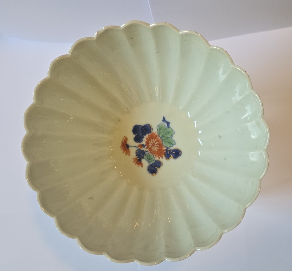 A fluted late 17th-century Japanese porcelain bowl decorated with polychrome floral enamel motifs against an off-white background. View XI
