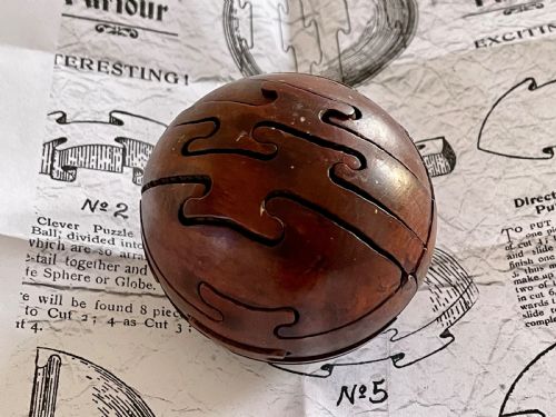an early 1900's antique treen jigsaw in the shape of a wooden ball - CATEGORY: ANTIQUE MISCELLANEOUS - DATED 1900