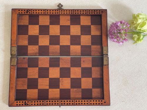 fig 1. A rectangular Georgian folding wooden games board featuring central oval shell marquetry inlay, crossbanded borders, and a brass latch on the side.