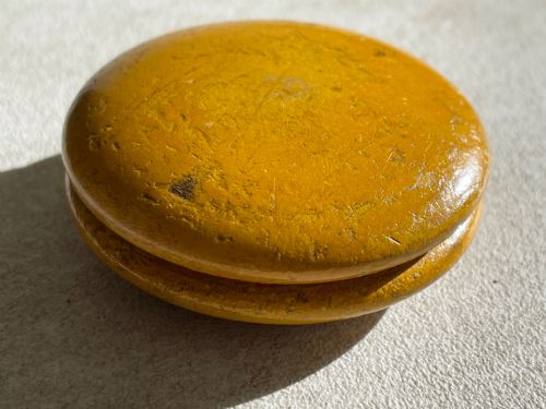 fig 1. A circular yellow wooden antique Scottish snuff box with a printed love poem on the top lid.