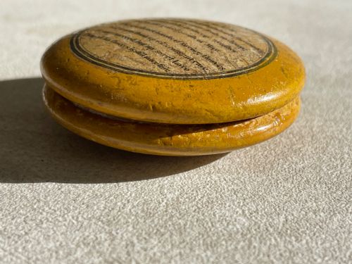 fig 2. A circular yellow wooden antique Scottish snuff box with a printed love poem on the top lid.