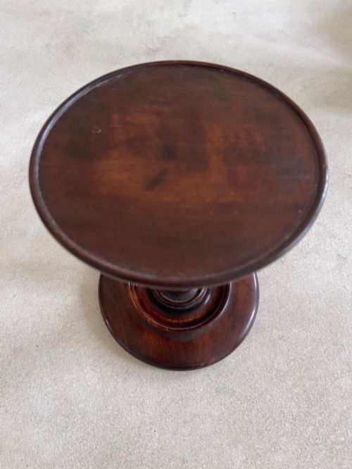 fig 1. A dark turned mahogany Georgian candle stand featuring a height-adjustment screw mechanism, a dished circular top tray, and a wide circular base.