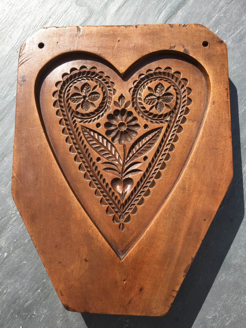 An antique heart shaped cake mould