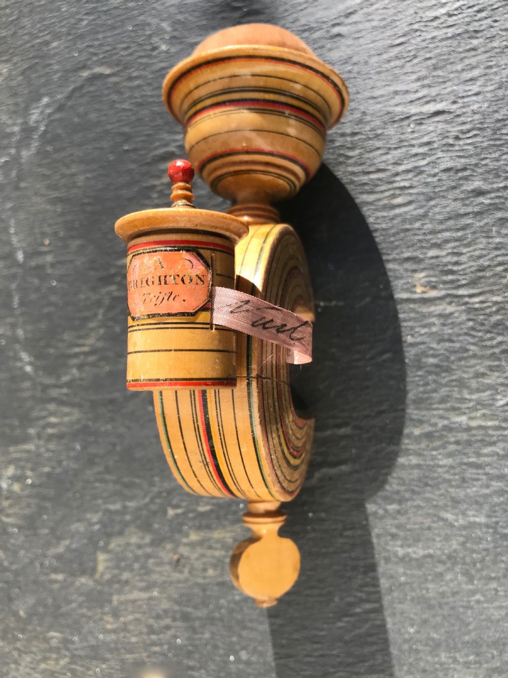 An early 19th century painted Tunbridge Ware sewing clamp, pin cushion and tape measure