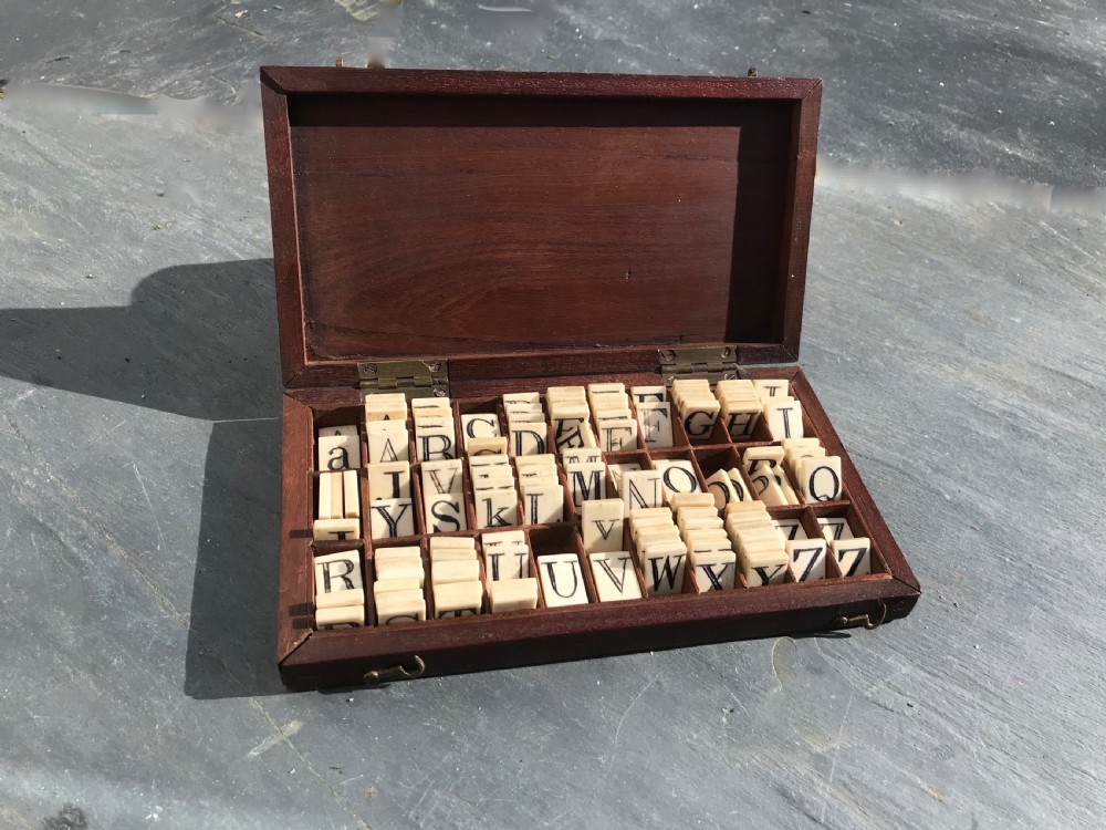 A 19th century mahogany boxed set of bone alphabet tiles