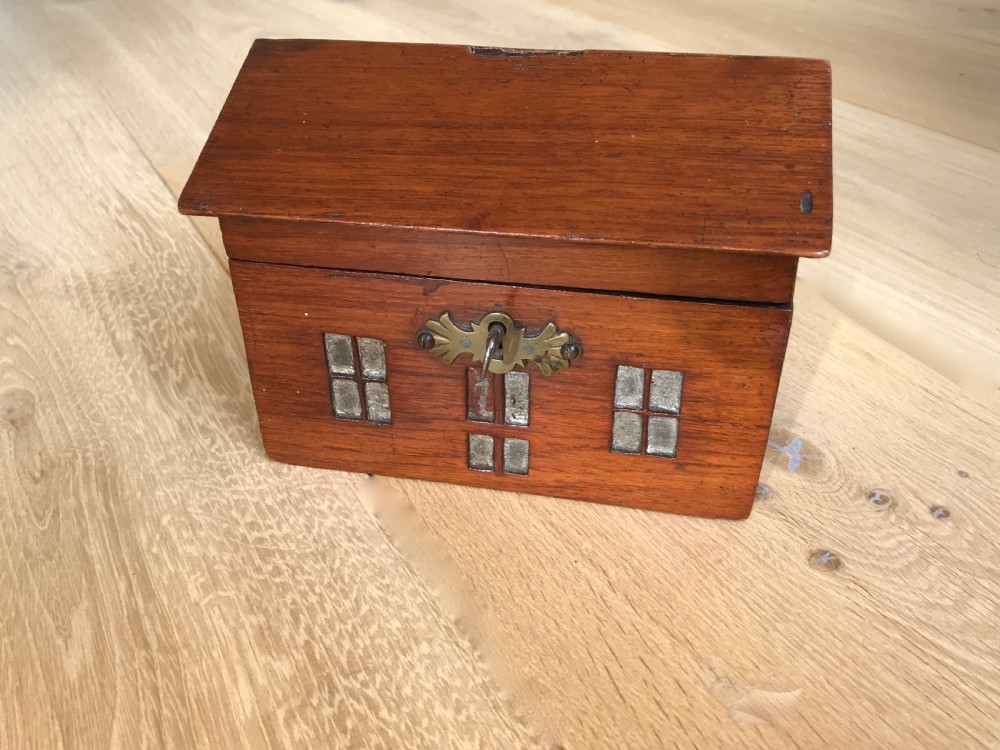 An unusual mahogany money box in the shape of a house - treen
