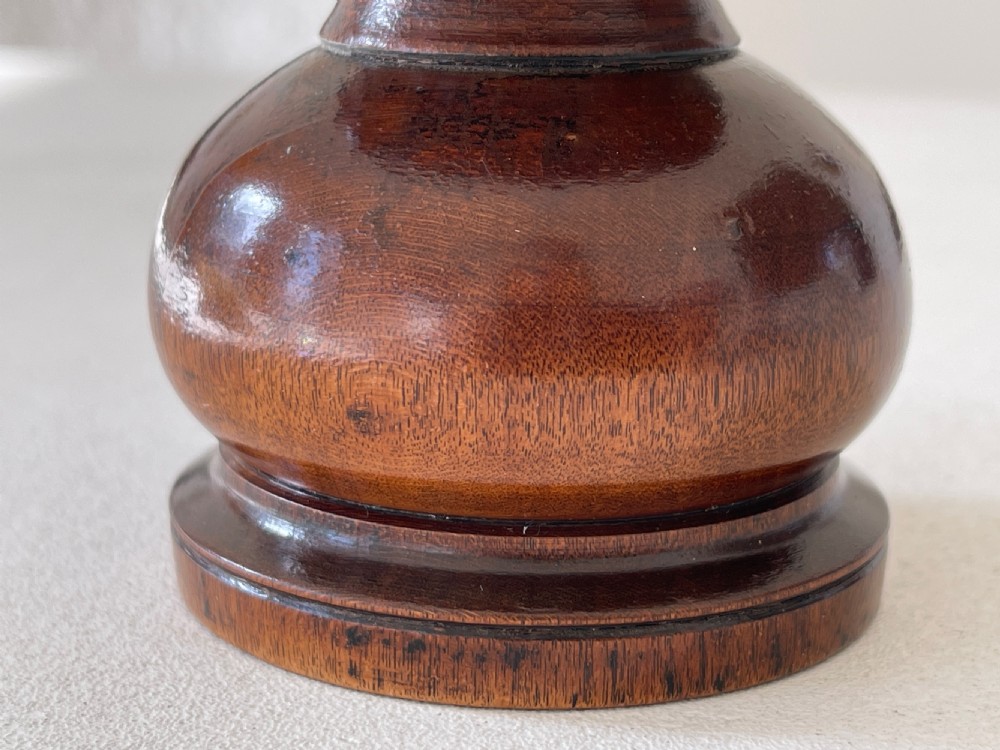 A turned dark fruitwood pounce pot featuring a perforated concave top dish above a bulbous stem and circular moulded base. View II