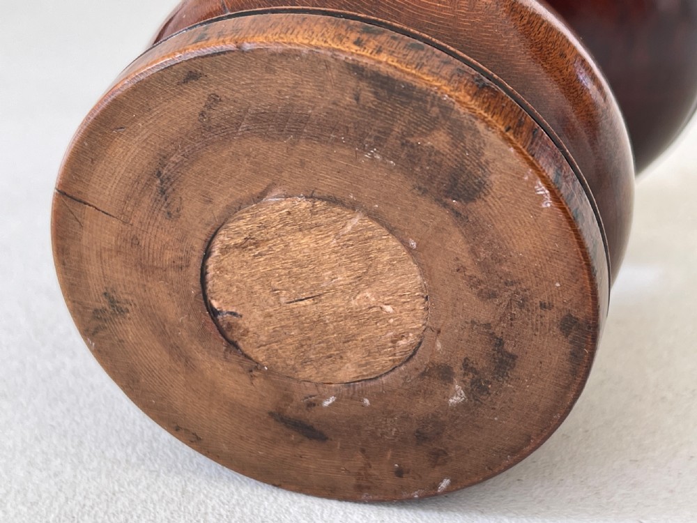 A turned dark fruitwood pounce pot featuring a perforated concave top dish above a bulbous stem and circular moulded base. View III