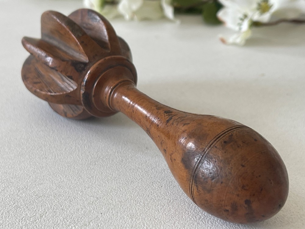 A turned wooden antique citrus reamer featuring carved reeded ribs and a rounded ergonomic handle with scored detail. View VI