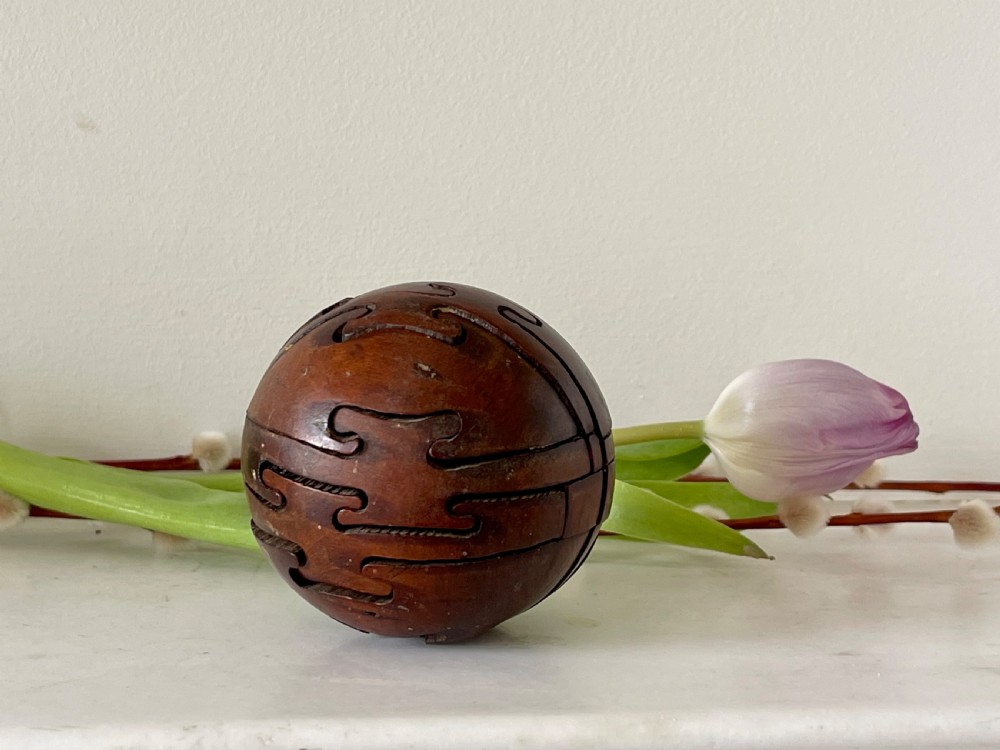 An early 1900's antique treen jigsaw in the shape of a wooden ball View II
