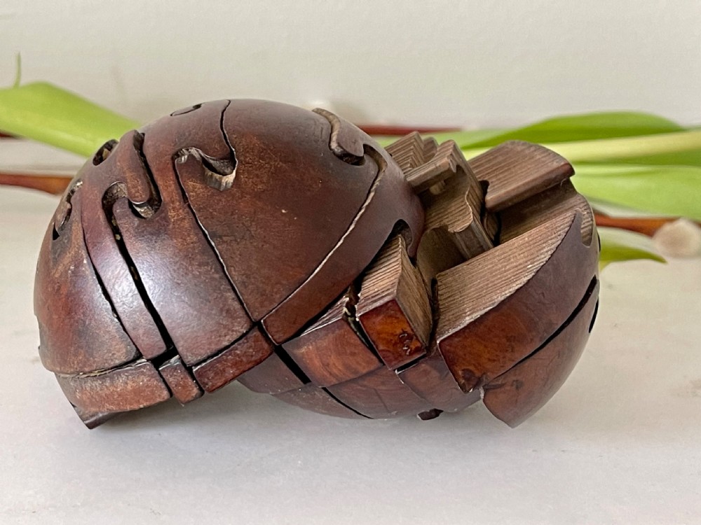 An early 1900's antique treen jigsaw in the shape of a wooden ball View III