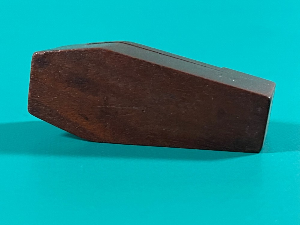 A small dark wood coffin-shaped antique snuff box featuring a swivelling lid with inlaid heart and diamond shapes. View V