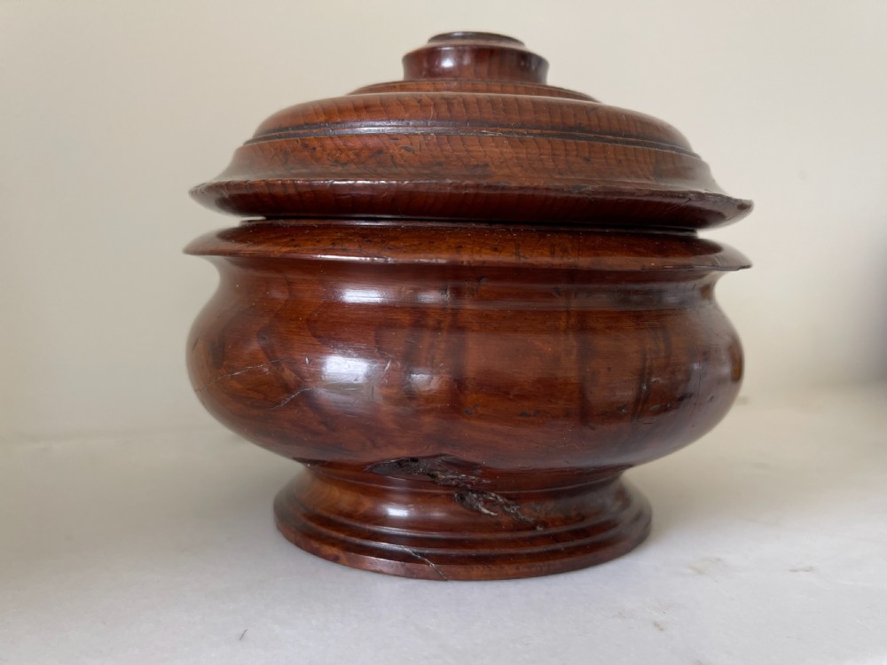 A turned yew wood spice pot featuring a stepped lidded top and a circular pedestal base. View V