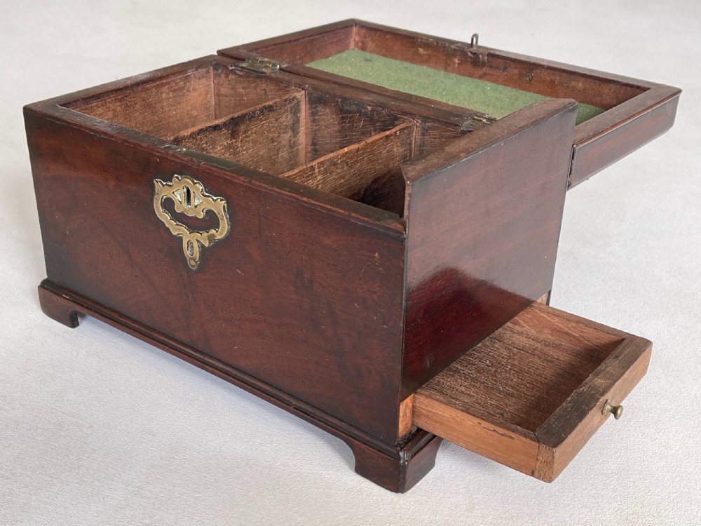 A rectangular dark mahogany tea caddy featuring a brass carrying handle on the lid and an ornate brass keyhole escutcheon on the front. View VII