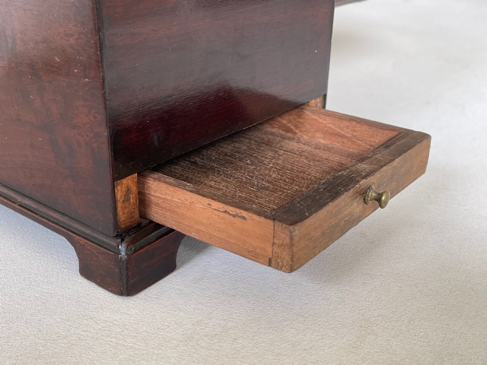 A rectangular dark mahogany tea caddy featuring a brass carrying handle on the lid and an ornate brass keyhole escutcheon on the front. View VIII