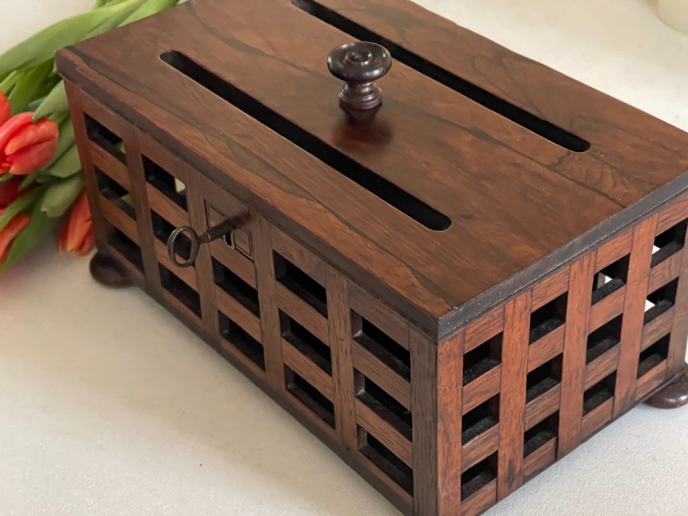 A rectangular antique rosewood stationery box featuring an open lattice exterior, a top lifting knob, bun feet, and an integrated key in the lock. View II