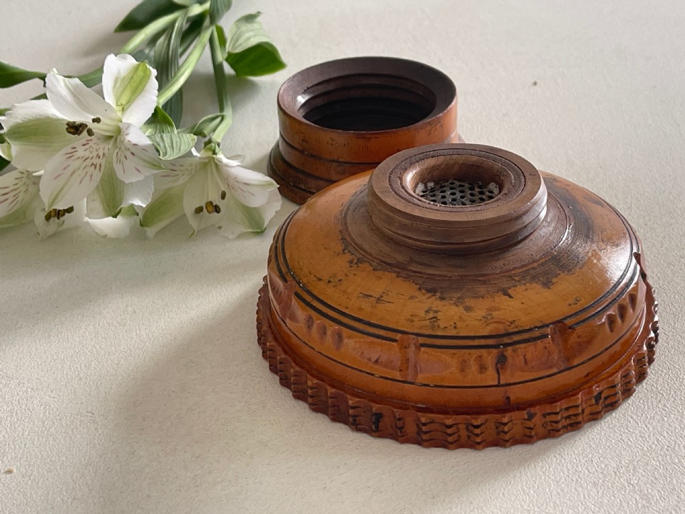 A small turned warm brown wooden Georgian searce with a carved wavy rim, pedestal base, and perforated strainer bottom. View VIII