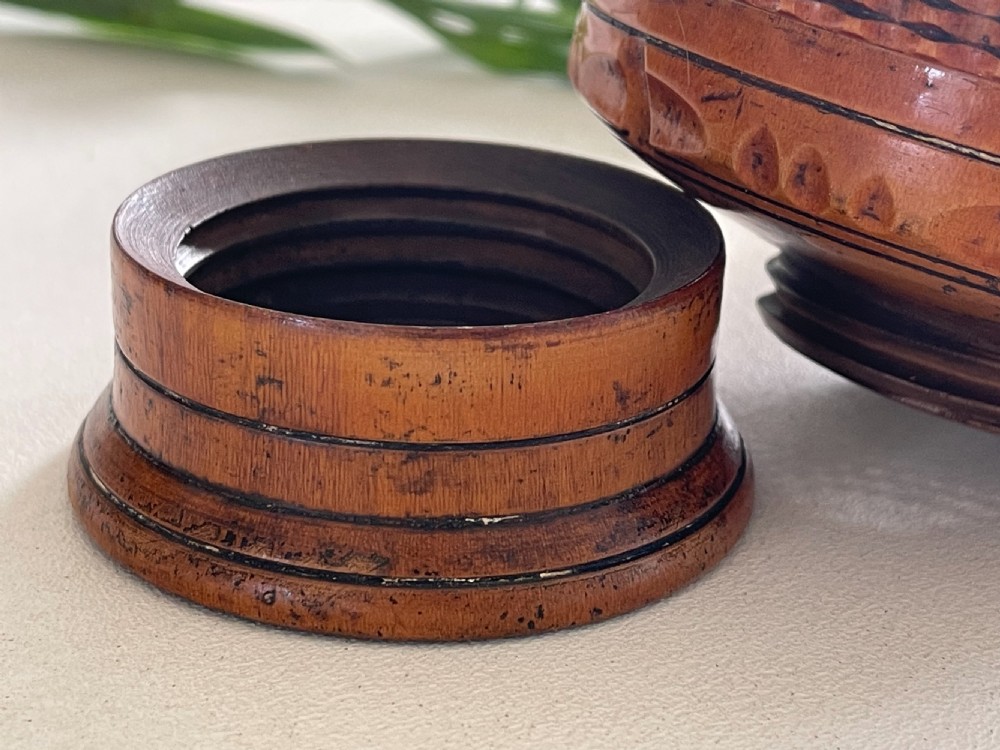 A small turned warm brown wooden Georgian searce with a carved wavy rim, pedestal base, and perforated strainer bottom. View XII
