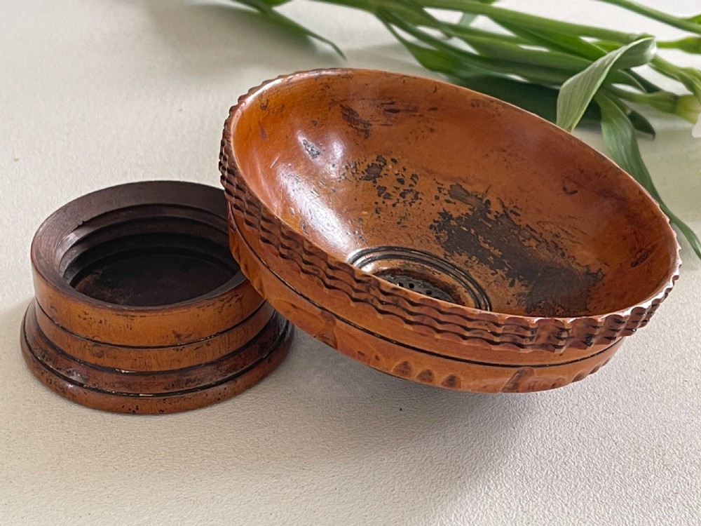 A small turned warm brown wooden Georgian searce with a carved wavy rim, pedestal base, and perforated strainer bottom. View XIII