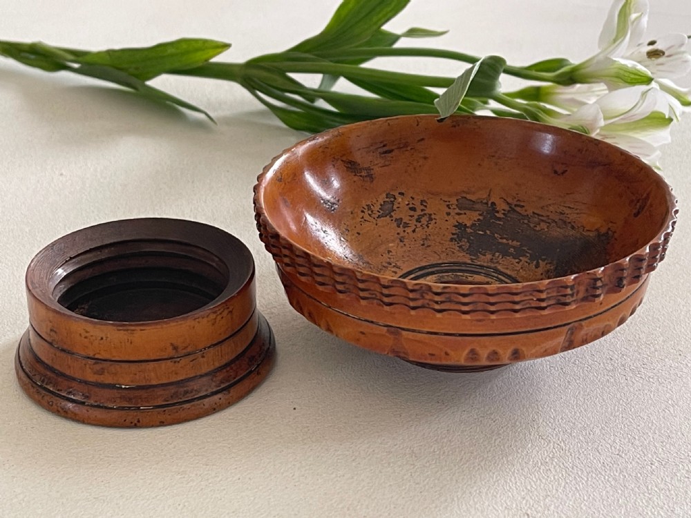 A small turned warm brown wooden Georgian searce with a carved wavy rim, pedestal base, and perforated strainer bottom. View XIV