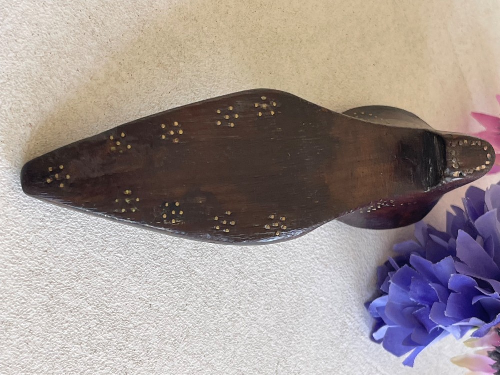 A carved dark wood snuff box fashioned in the shape of a shoe, decorated with brass pinwork floral patterns and a sliding lid on top. View III
