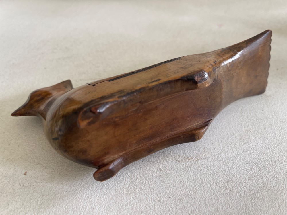 A small hand-carved wooden snuff box shaped like a bird with a polished natural timber grain and integrated hinged lid. View IV