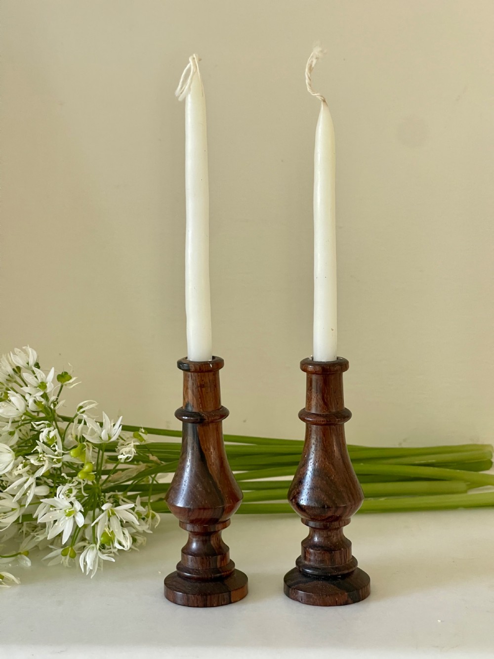 A pair of small turned dark wood taper candlesticks featuring baluster-shaped shafts and circular flat bases. View IV
