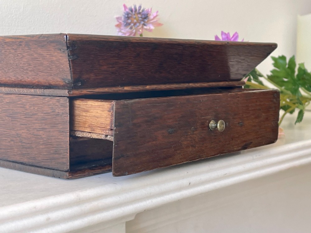 A dark oak rectangular desk tidy featuring a wide flared top tray above a single drawer fitted with a small brass knob. View II
