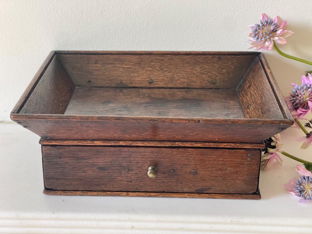 A dark oak rectangular desk tidy featuring a wide flared top tray above a single drawer fitted with a small brass knob. View III