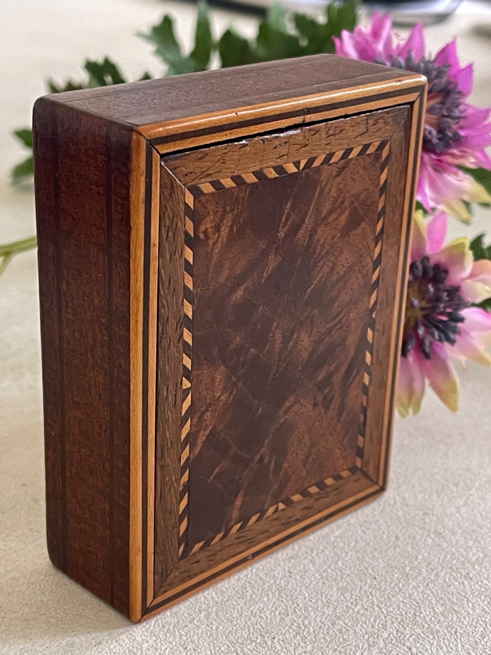 A small rectangular brown timber snuff box featuring a sliding lid with geometric chevron inlay detailing. View VI