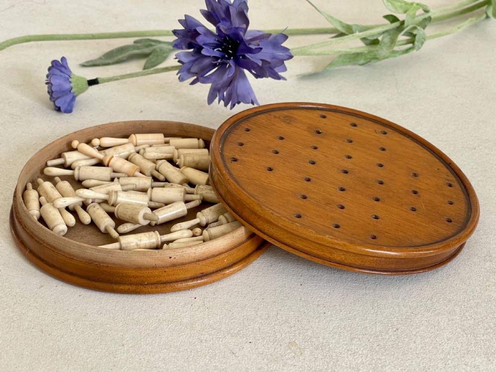 An Antique Treen Travelling Solitaire Game- complete with all its bone pegs