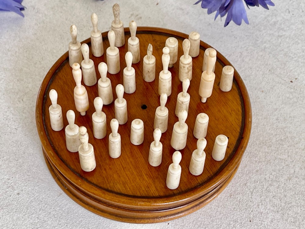 An Antique Treen Travelling Solitaire Game- complete with all its bone pegs View V