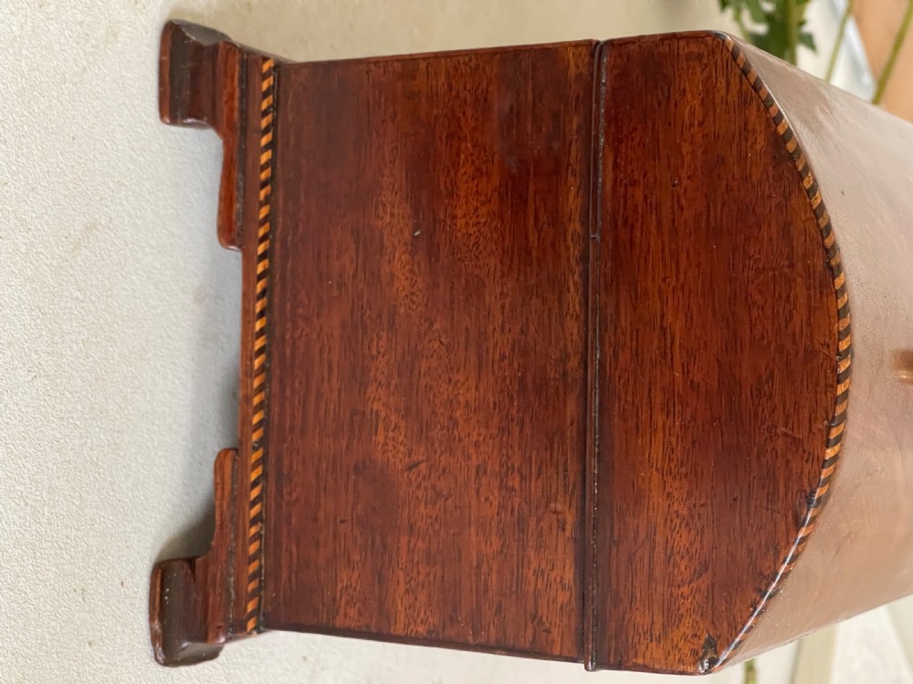 A rectangular Georgian flame mahogany tea caddy with a domed lid, brass carrying handles, and a bone keyhole escutcheon. View IV