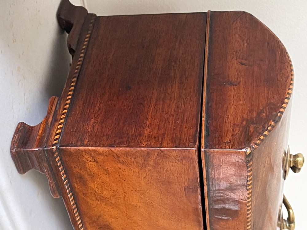 A rectangular Georgian flame mahogany tea caddy with a domed lid, brass carrying handles, and a bone keyhole escutcheon. View VI
