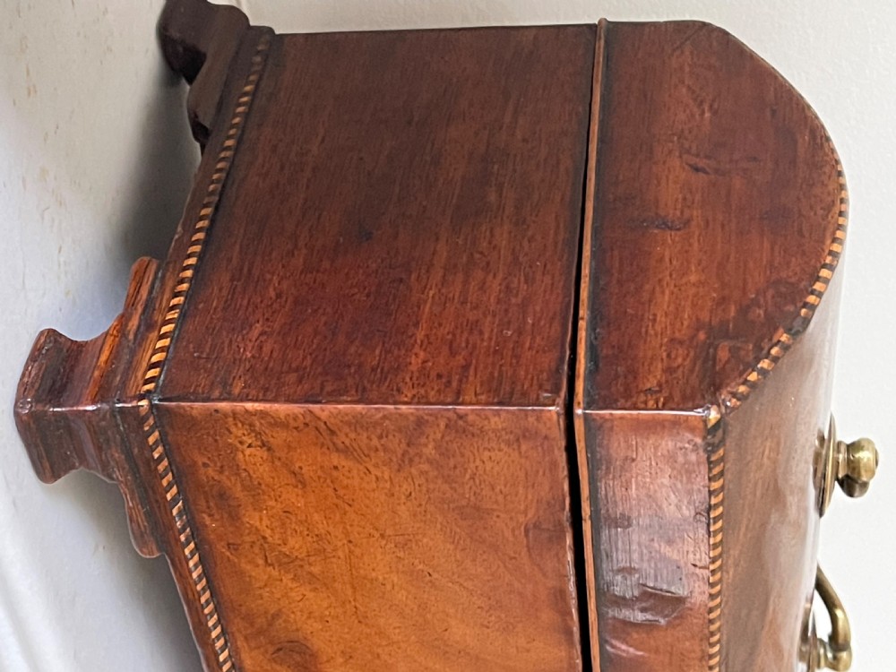 A rectangular Georgian flame mahogany tea caddy with a domed lid, brass carrying handles, and a bone keyhole escutcheon. View VII