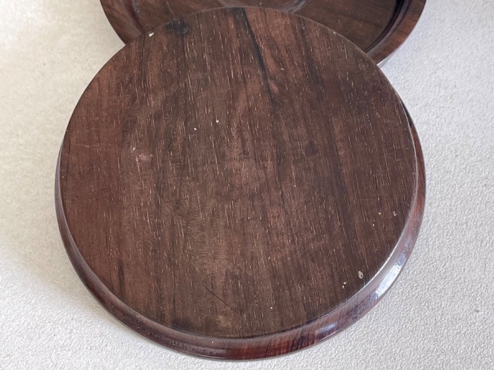 A pair of circular turned dark rosewood wine bottle coasters with raised rims and recessed centres. View IV