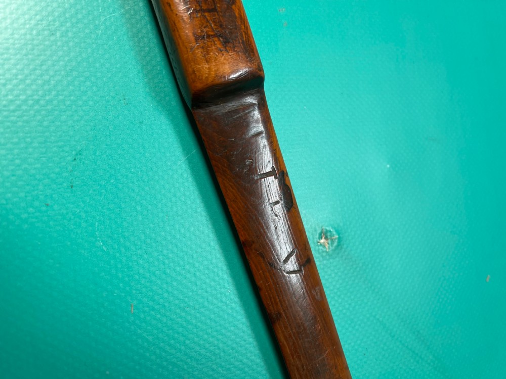 An antique hand-carved yew wood letter opener with a thick rounded handle tapering into a smooth blade. View III