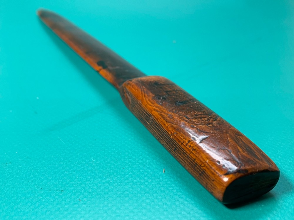 An antique hand-carved yew wood letter opener with a thick rounded handle tapering into a smooth blade. View V