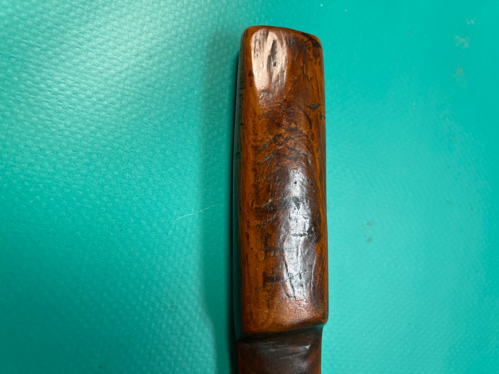 An antique hand-carved yew wood letter opener with a thick rounded handle tapering into a smooth blade. View VI