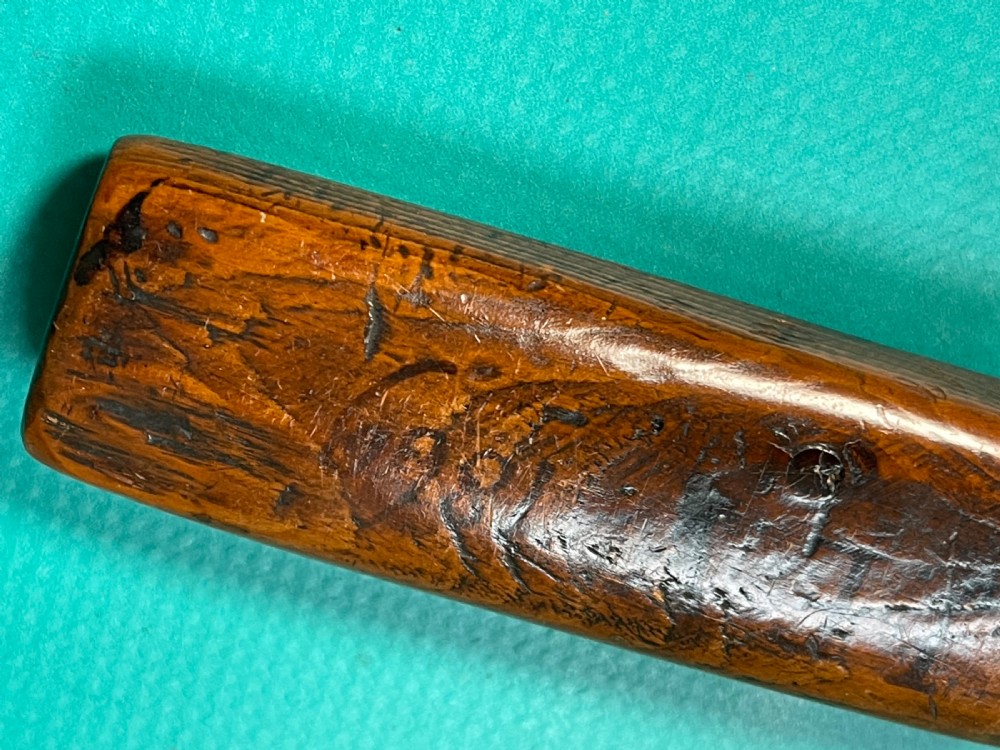 An antique hand-carved yew wood letter opener with a thick rounded handle tapering into a smooth blade. View VIII