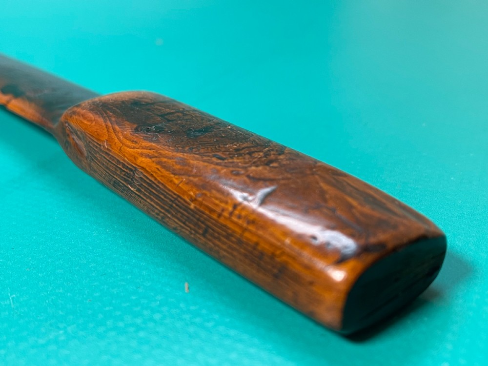 An antique hand-carved yew wood letter opener with a thick rounded handle tapering into a smooth blade. View X