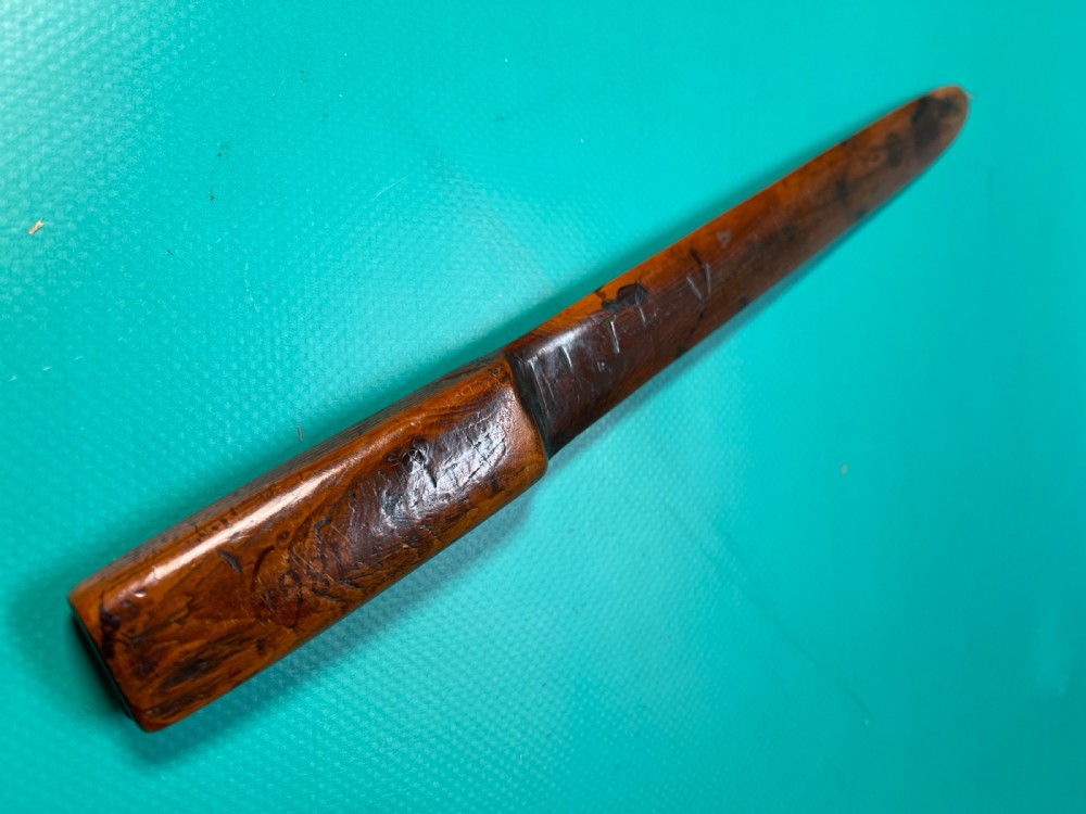 An antique hand-carved yew wood letter opener with a thick rounded handle tapering into a smooth blade. View XI